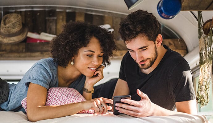 man enjoying meal looking at cell phone launching Norton 360 Standard.